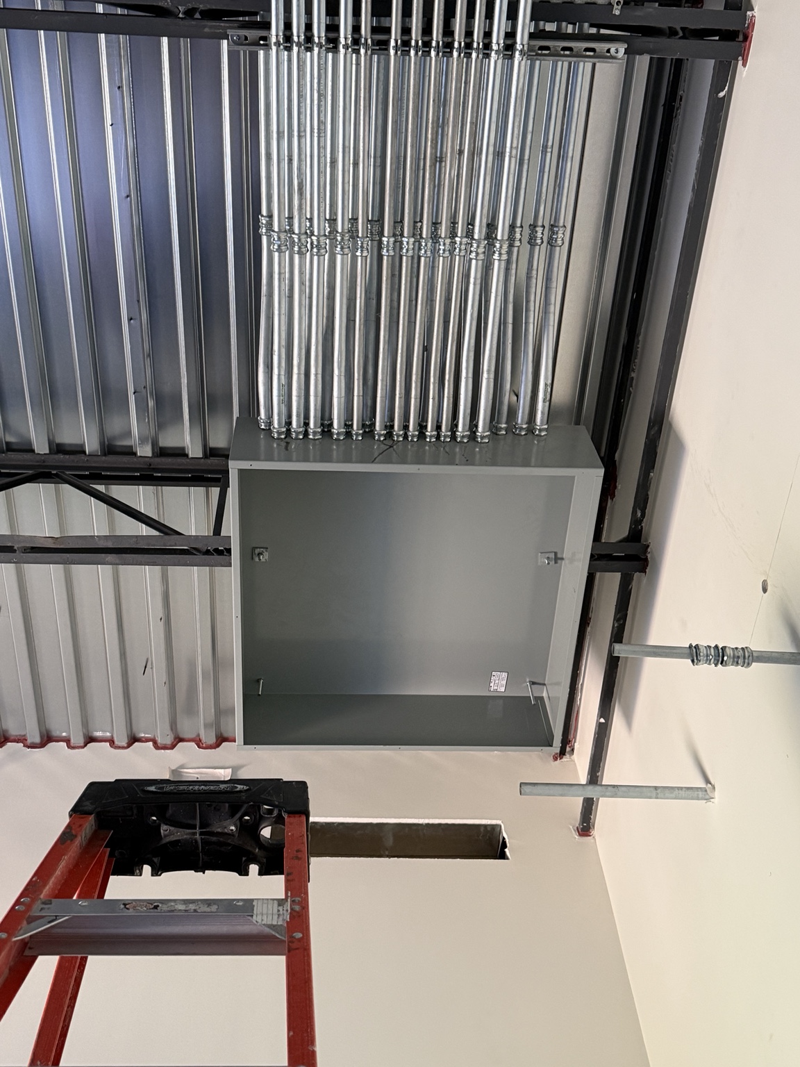 Mounted electrical panel box with multiple conduit runs